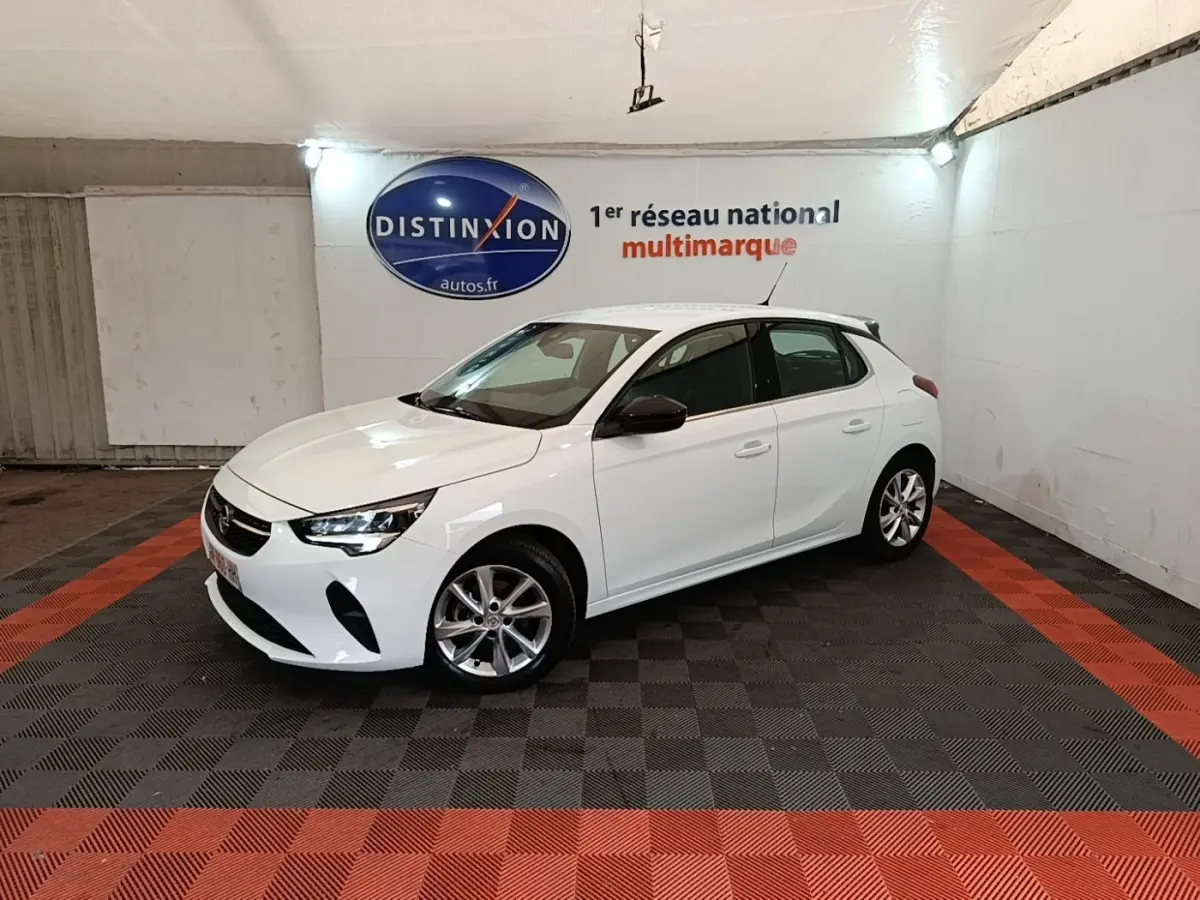 Opel Corsa blanc vue 3/4 avant droit dans un showroom avec jantes alliage et rétroviseurs noirs.