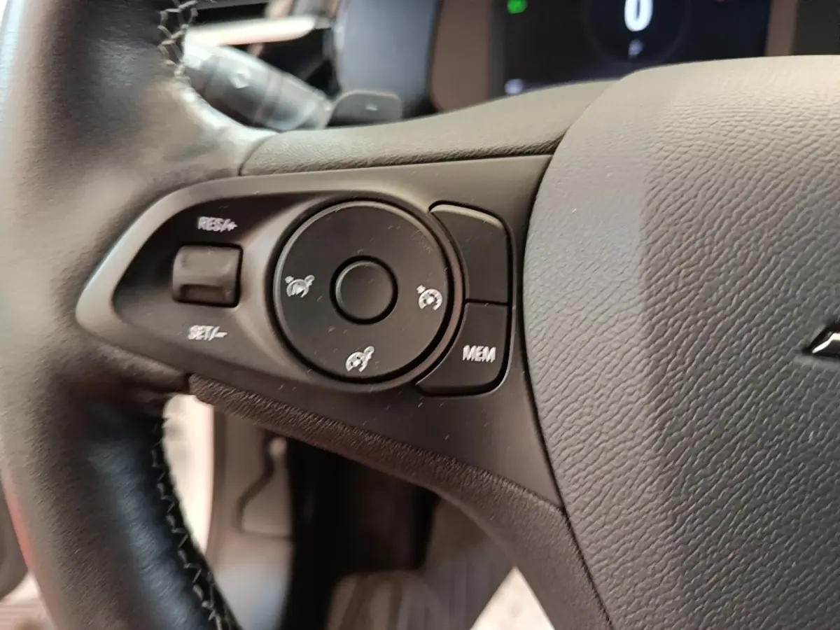 Gros plan sur le volant cuir noir de l’Opel Corsa 2022, avec commandes multifonctions côté gauche visibles.