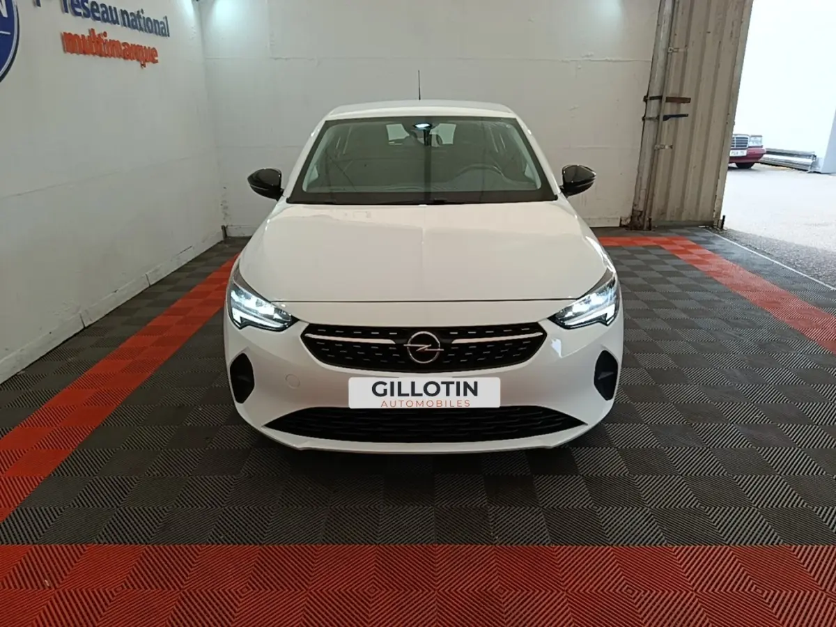 Vue frontale d'une Opel Corsa blanche 2022 avec phares LED allumés dans un garage intérieur.