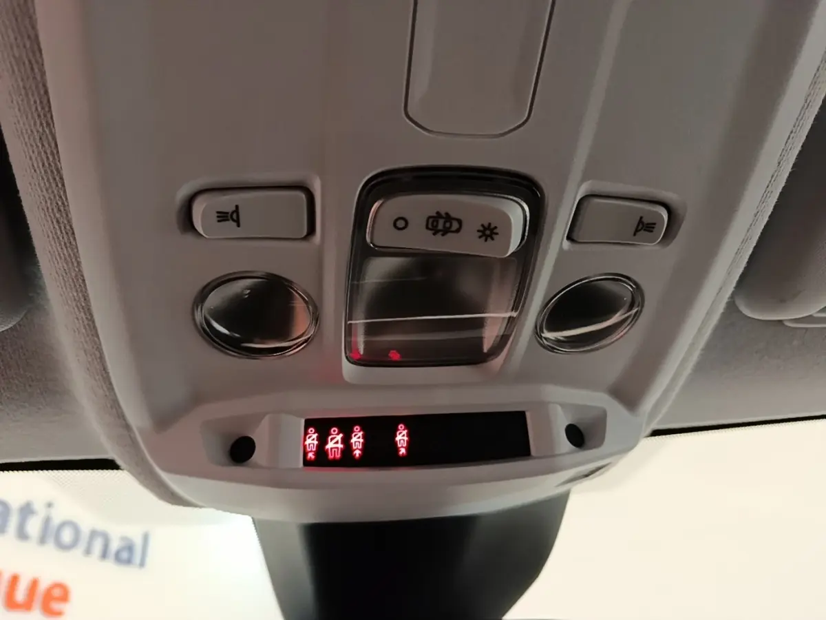 Vue en gros plan du plafonnier intérieur blanc de l’Opel Corsa 2022 avec commandes d’éclairage et indicateurs rouges.