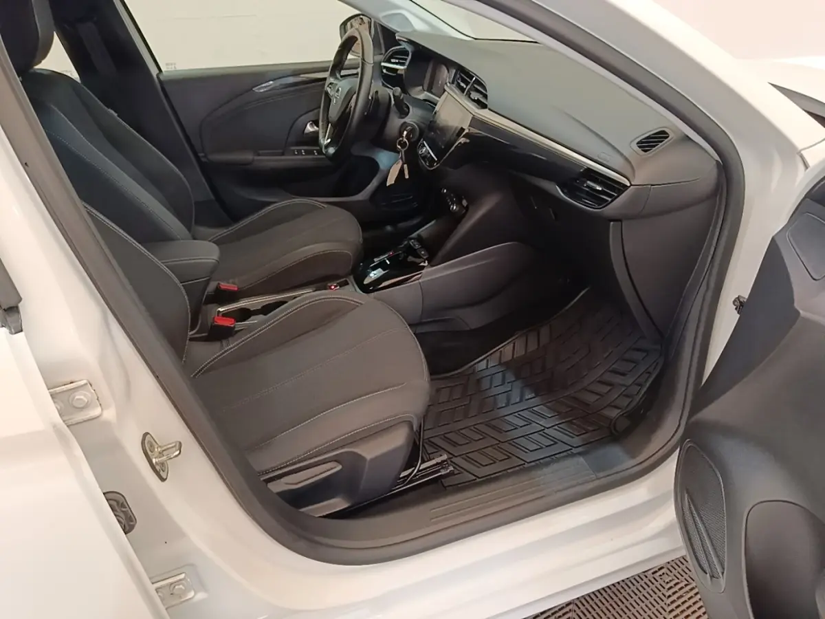 Vue intérieure côté conducteur de l'Opel Corsa blanc 2022, sièges noirs et tableau de bord avec écran tactile.