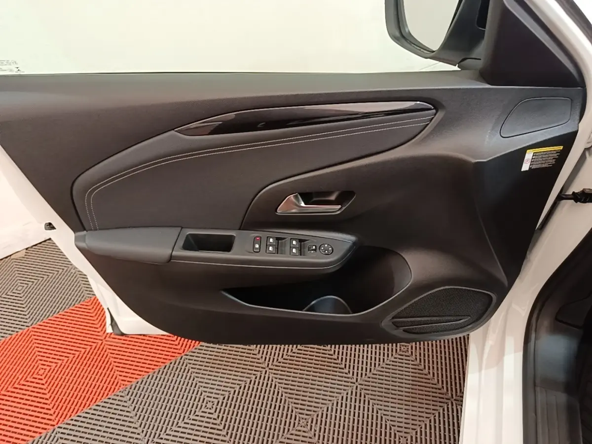 Vue rapprochée de la porte avant gauche blanche d'une Opel Corsa 2022, avec commandes électriques et garniture noire.