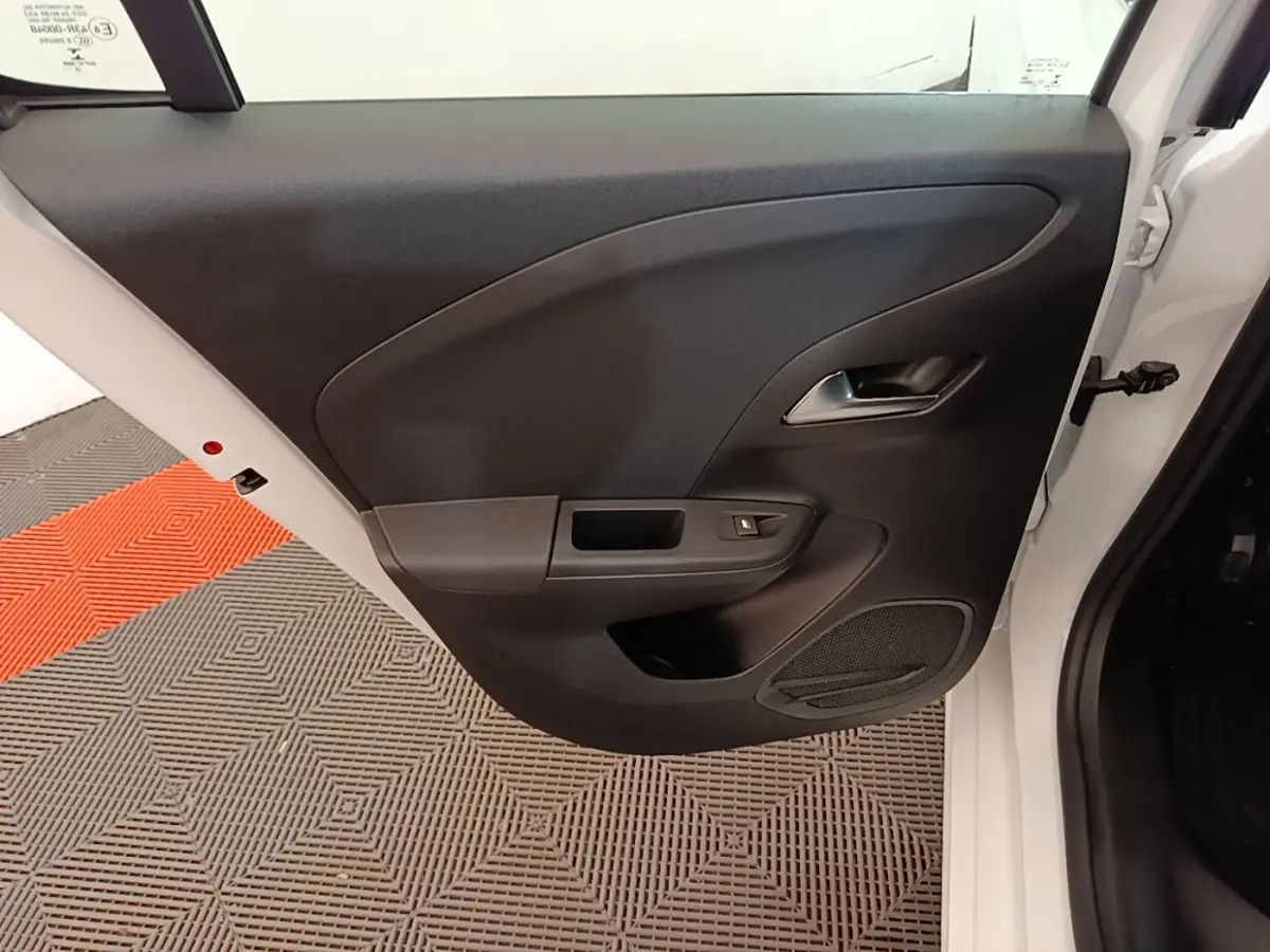 Vue rapprochée de la porte arrière droite blanche d'une Opel Corsa 2022 avec panneau intérieur noir et poignée chromée.