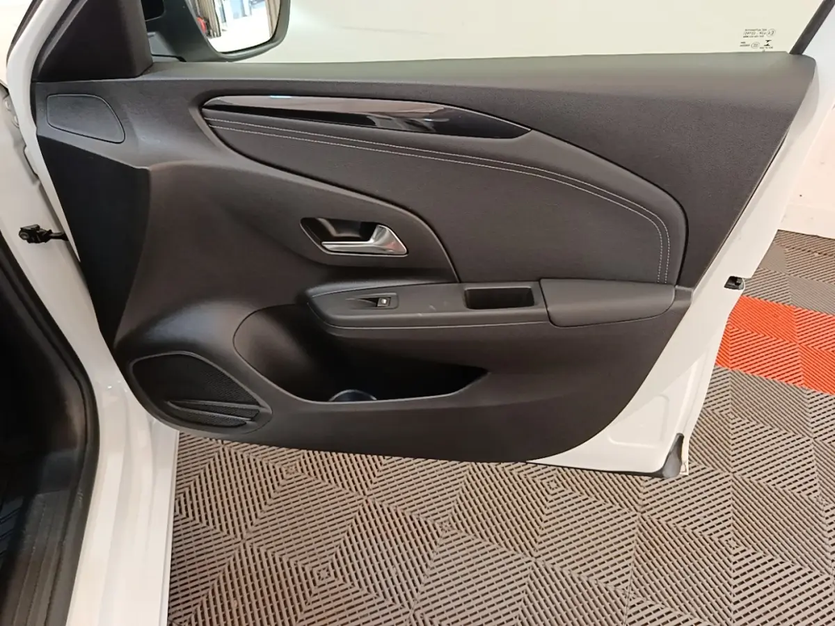 Vue intérieure de la porte avant gauche noire avec surpiqûres blanches d'une Opel Corsa blanche 2022.