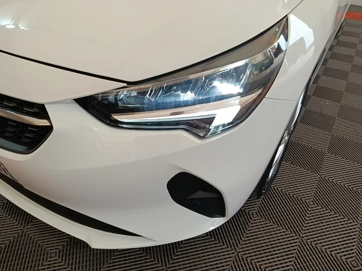 Gros plan sur l'avant droit blanc d'une Opel Corsa 2022, mettant en valeur le phare LED et la calandre.