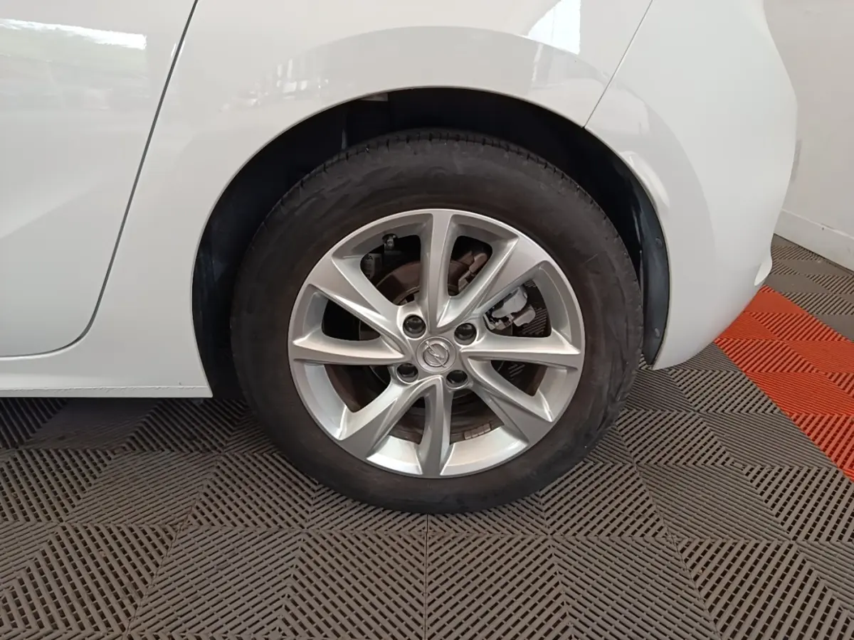 Gros plan sur la roue arrière droite d’une Opel Corsa blanche 2022 avec jante alliage à plusieurs branches.