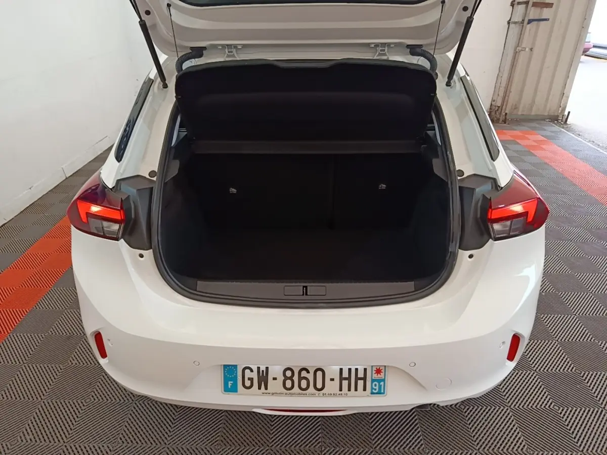 Vue arrière d'une Opel Corsa blanche 2022 avec coffre ouvert, feux arrière LED et plaque d'immatriculation visible.