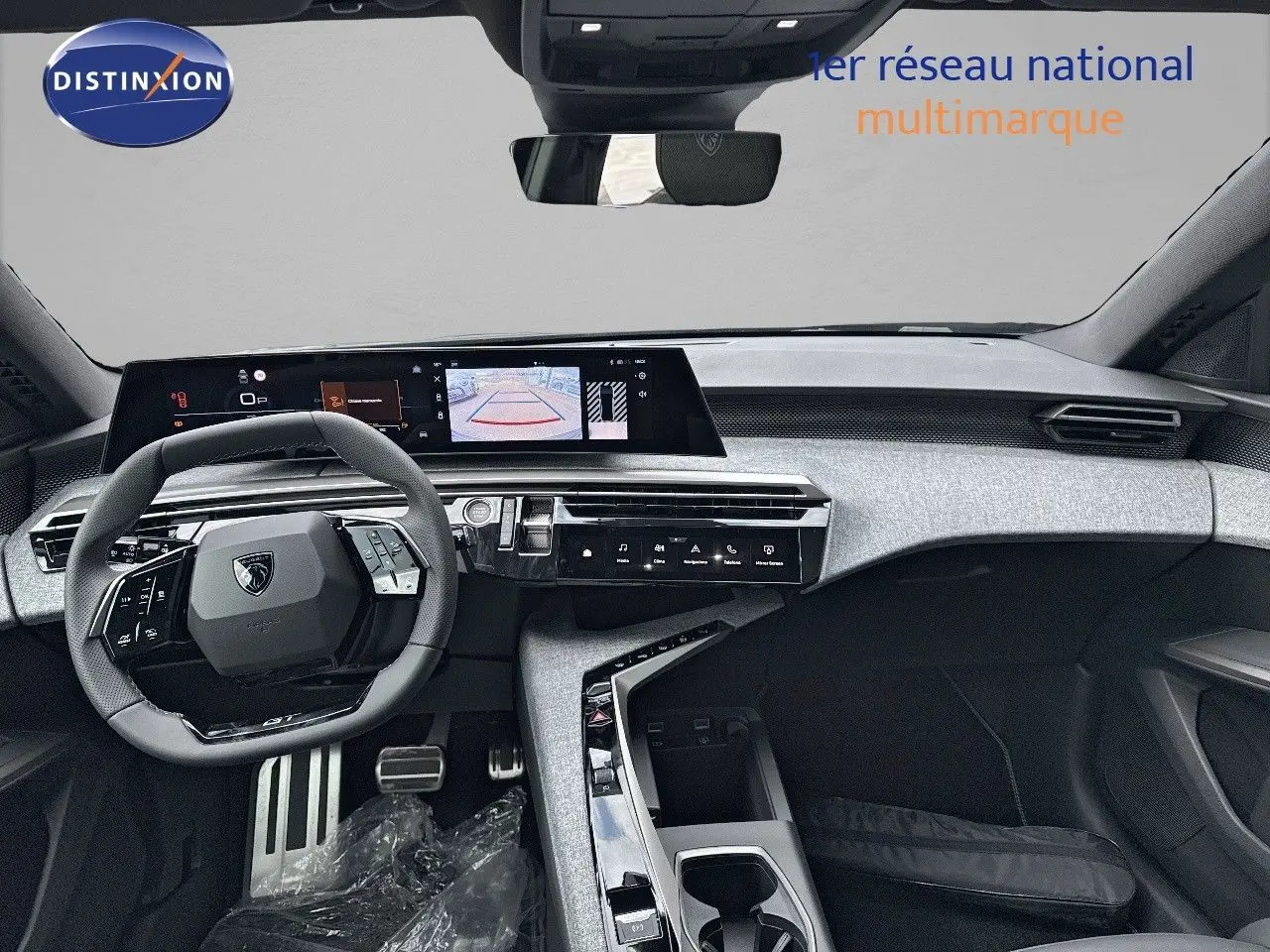 Vue intérieure du tableau de bord et volant du Peugeot 3008 Hybrid 2025 en noir perle métal, avec écran tactile et caméra de recul affichée.