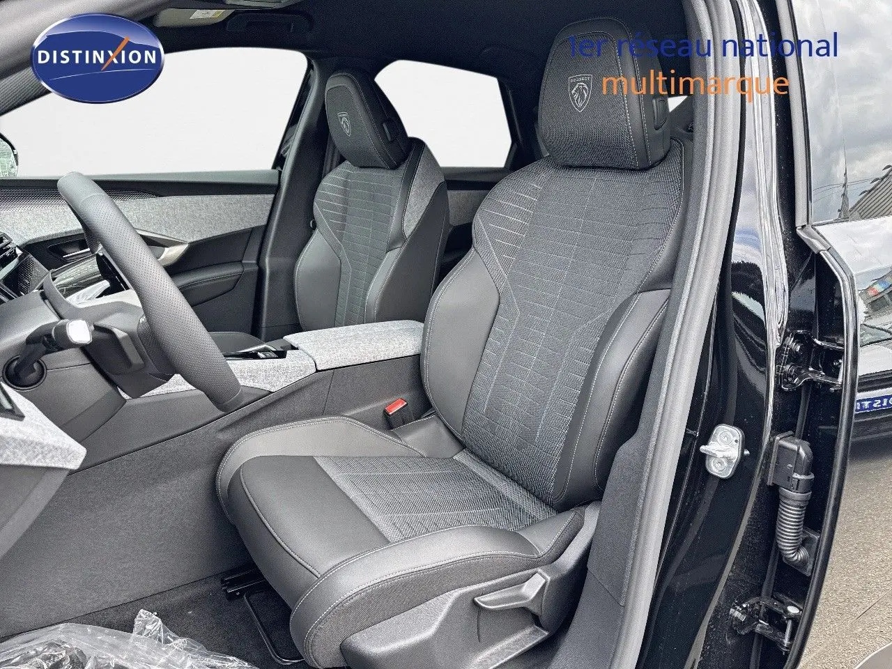 Vue intérieure côté conducteur du Peugeot 3008 Hybrid 136ch GT noir perle métal, sièges en cuir et tissu gris.