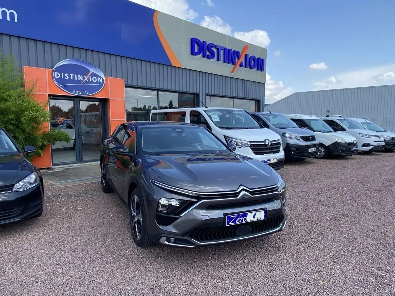 Citroën C5 X gris platinium vue 3/4 avant droit sur parking devant concession Distinxion.
