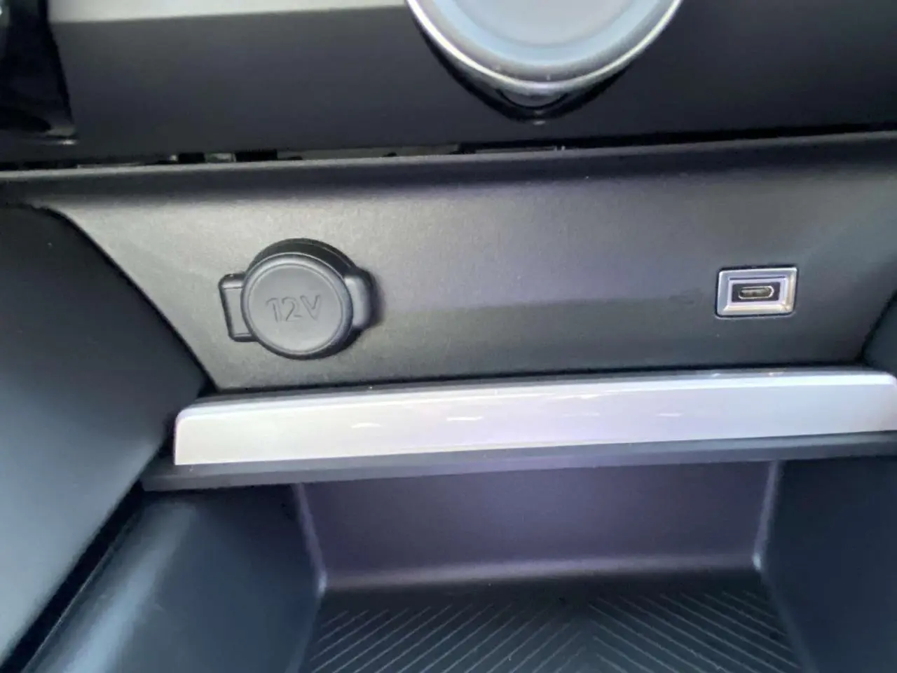 Prise 12V et port USB intégrés dans la console centrale noire du Citroën C5 X 2023 finition Feel Pack.
