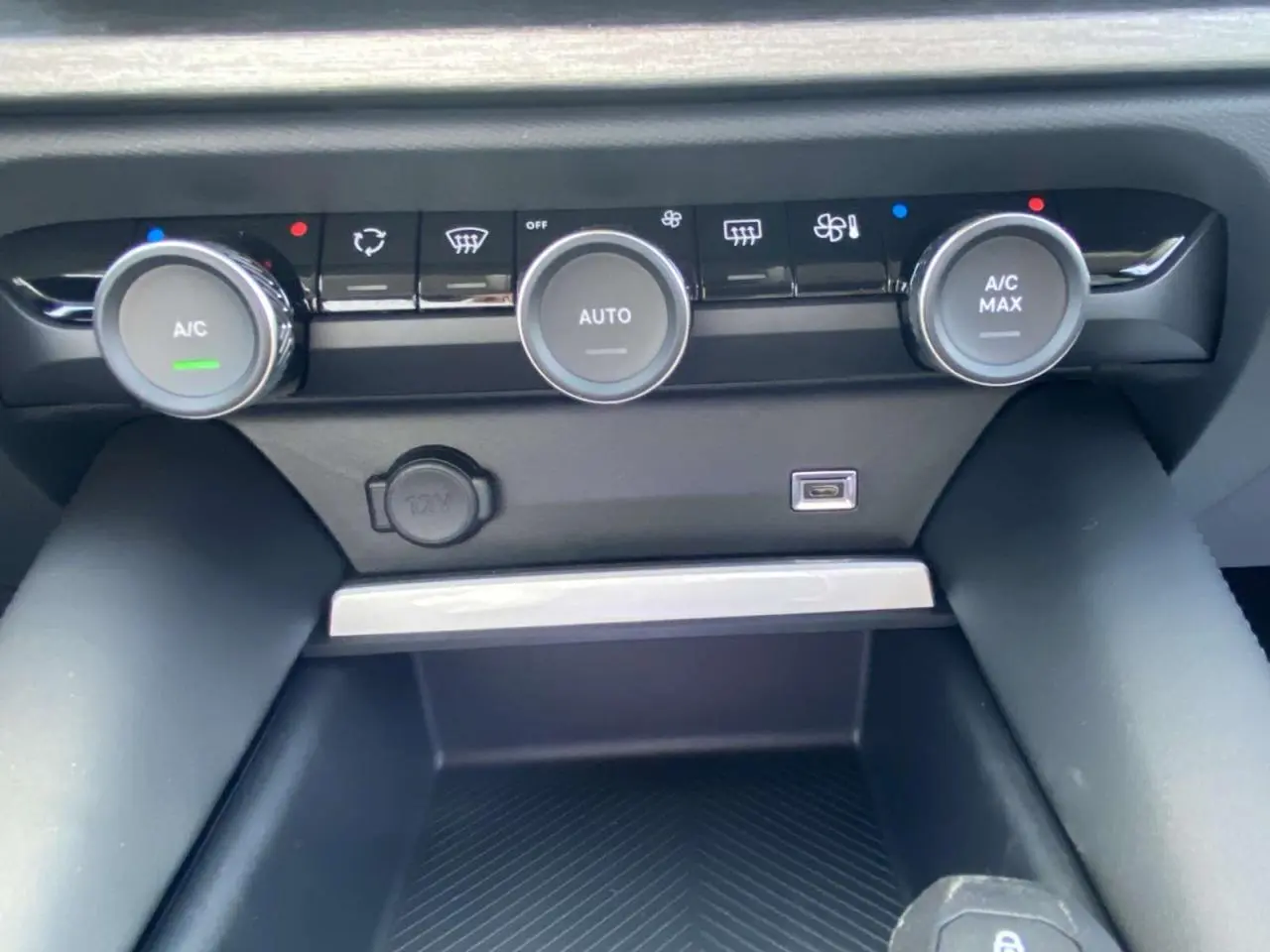 Gros plan sur la commande de climatisation automatique de la Citroën C5 X 2023 avec boutons rotatifs et prise USB.