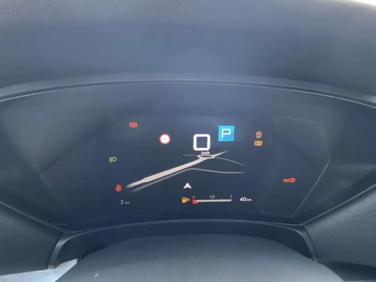 Tableau de bord numérique du Citroën C5 X 2023 affichant la vitesse à 0 km/h et l'indicateur de carburant faible.