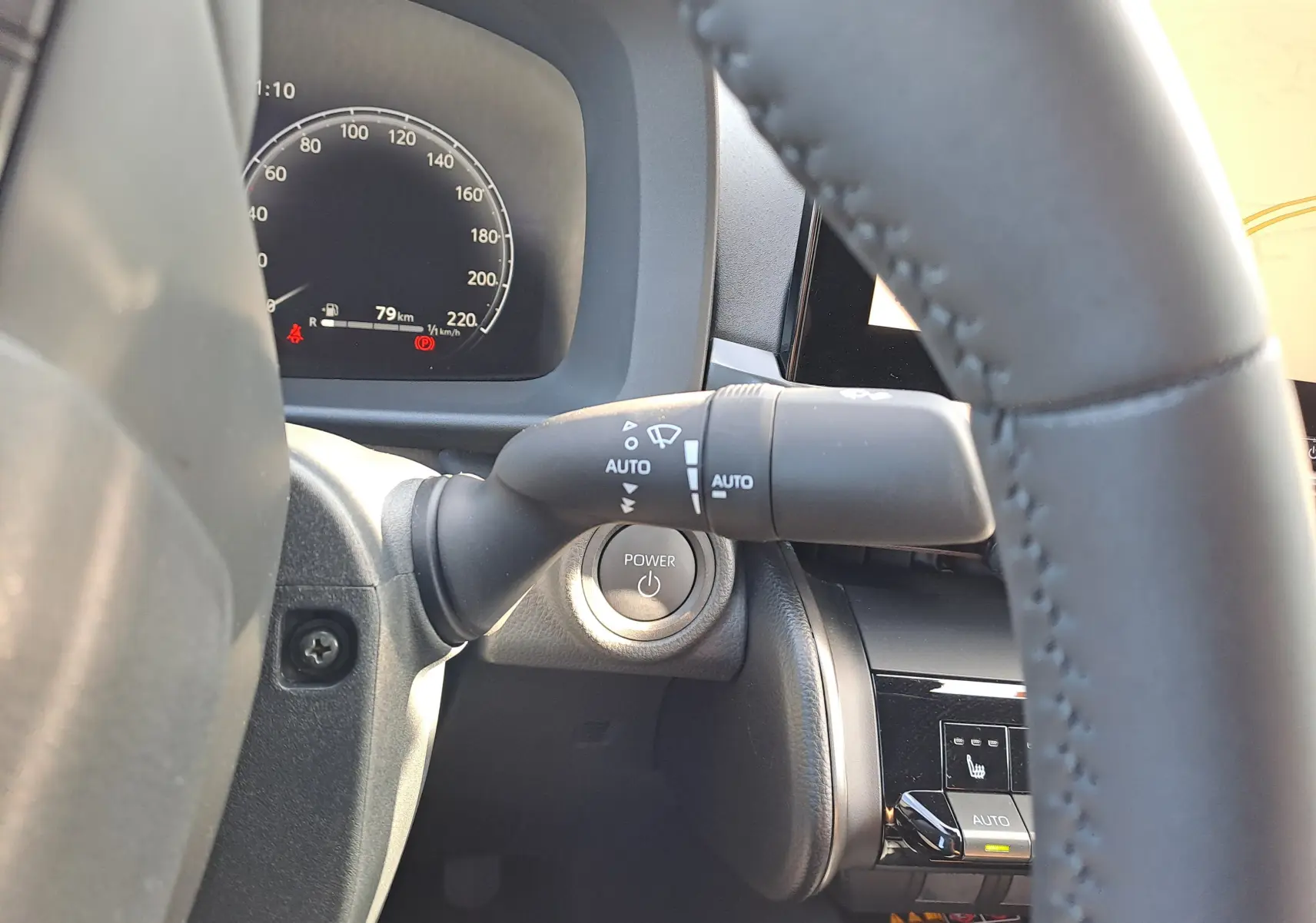 Vue depuis le poste de conduite du tableau de bord numérique du Toyota C-HR gris minéral, affichant les compteurs et indicateurs.