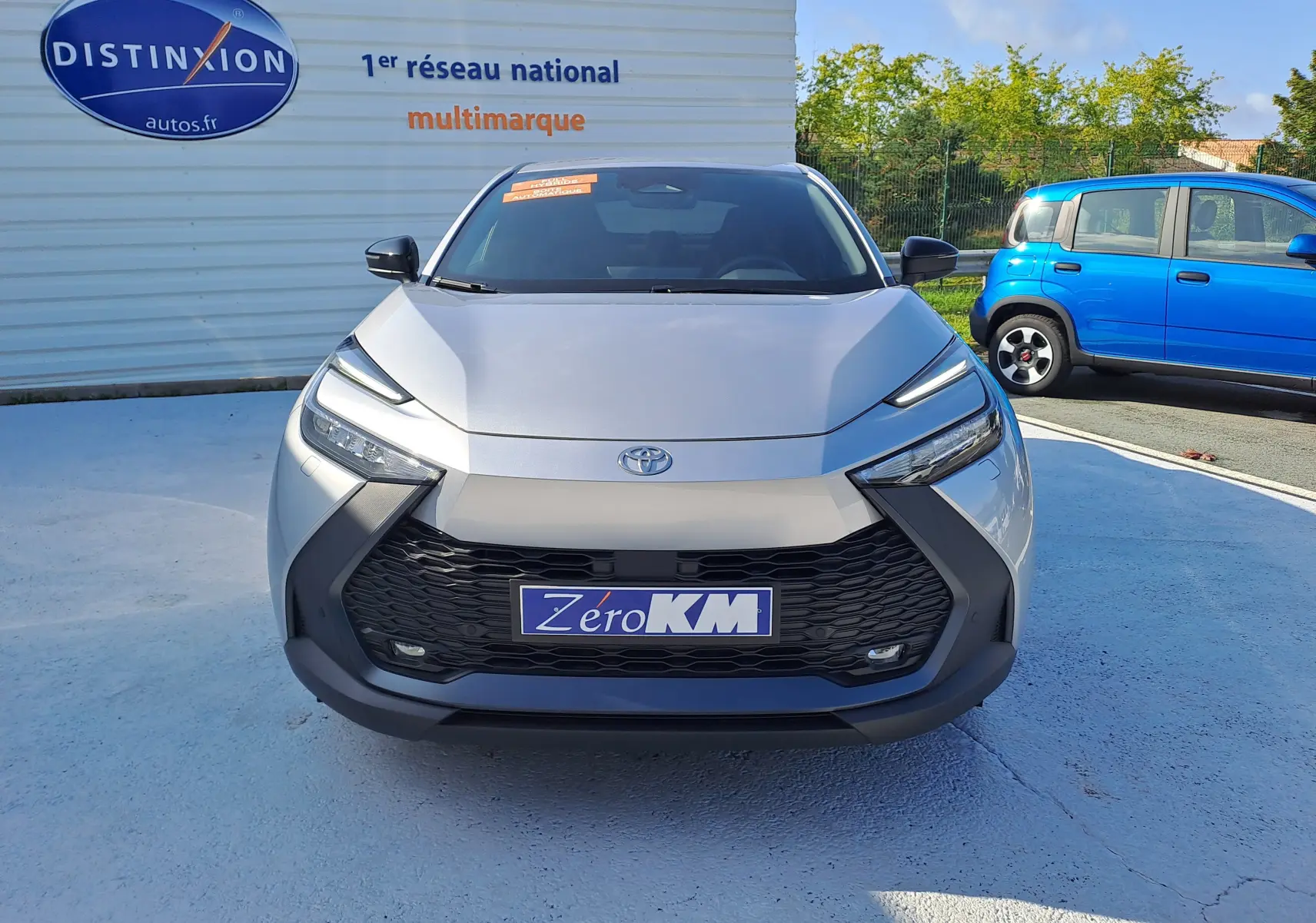 Vue frontale du Toyota C-HR II Style 1.8 Hybrid 140 gris minéral avec calandre noire et feux LED fins.