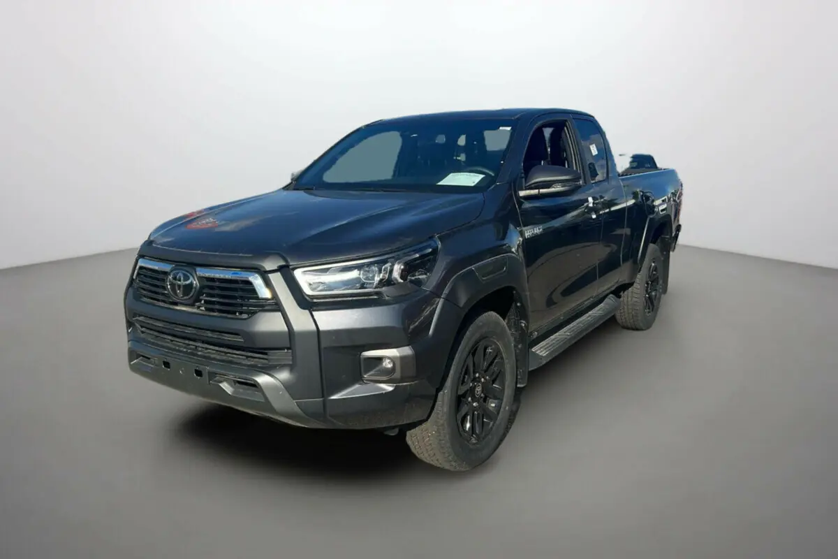 Toyota Hilux 4x4 Invincible 2025 gris atlas en 3/4 avant droit avec jantes noires et calandre marquée