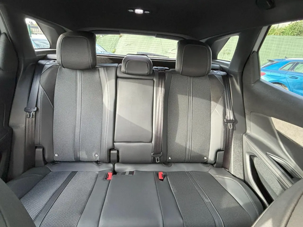 Vue arrière intérieure du Peugeot 3008 2024, sièges arrière en sellerie Mi-TEP/tissu noir avec surpiqûres grises.