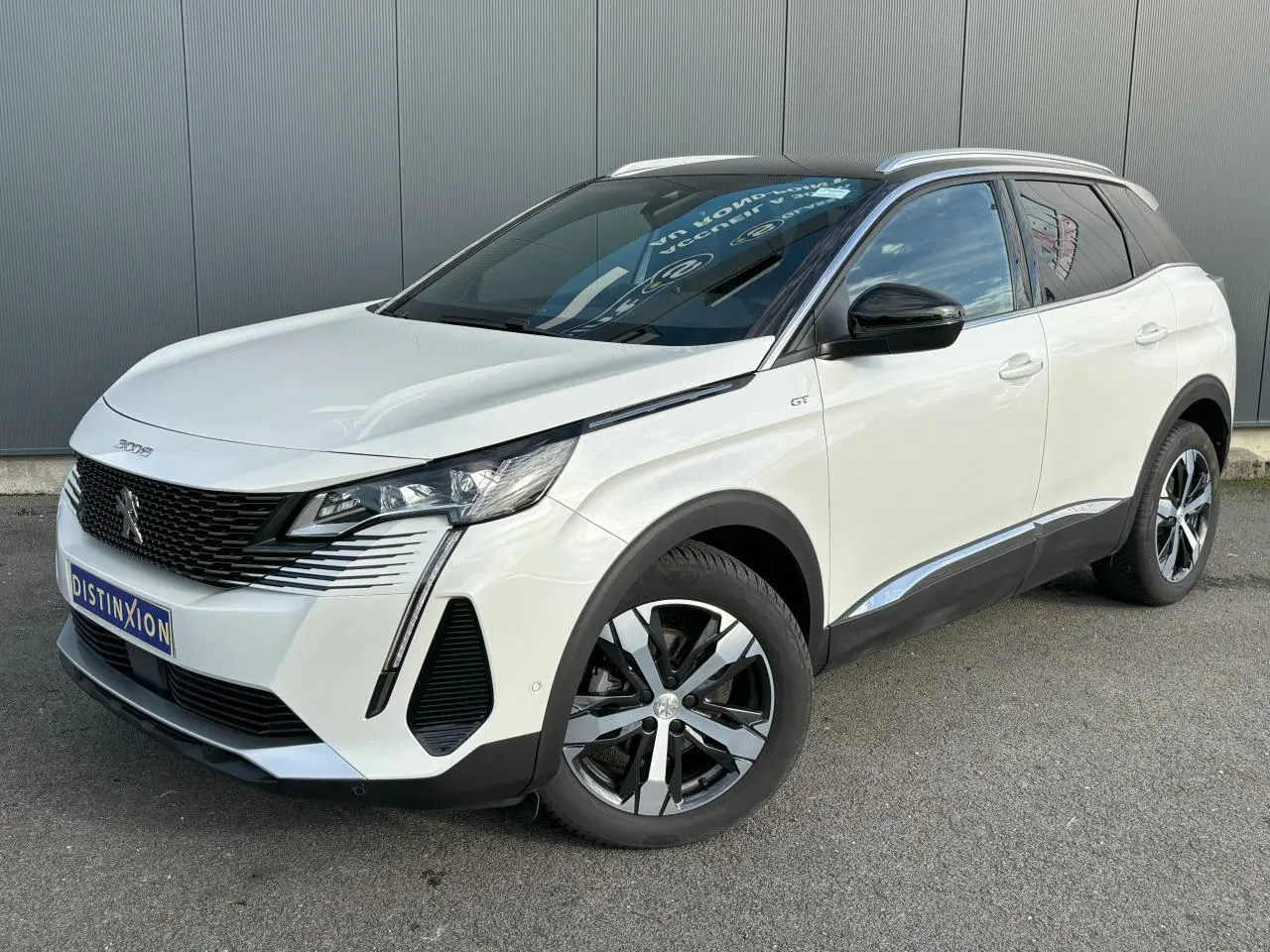 Peugeot 3008 blanc nacré vue 3/4 avant droit avec toit noir, jantes alliage bi-ton et badge GT sur aile.