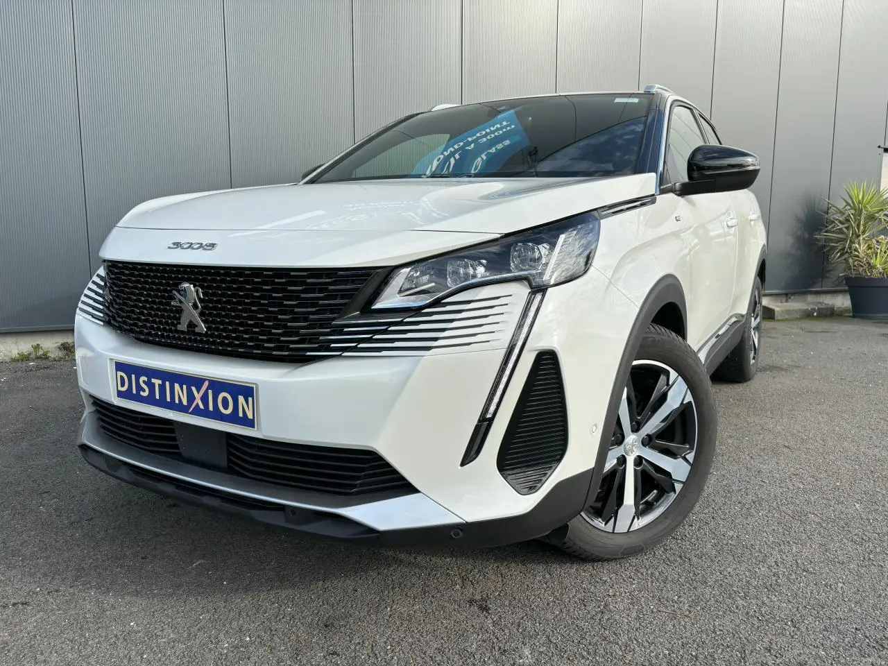 Peugeot 3008 blanc nacré vue 3/4 avant droit, avec calandre noire et jantes alliage bi-ton 18 pouces.