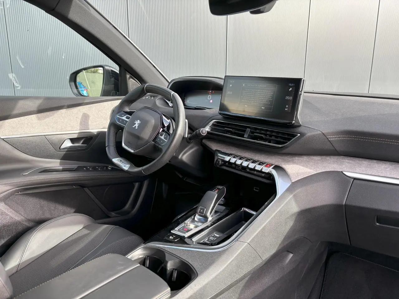 Vue intérieure côté conducteur du Peugeot 3008 2024, avec tableau de bord noir, écran tactile 10 pouces et volant compact cuir.