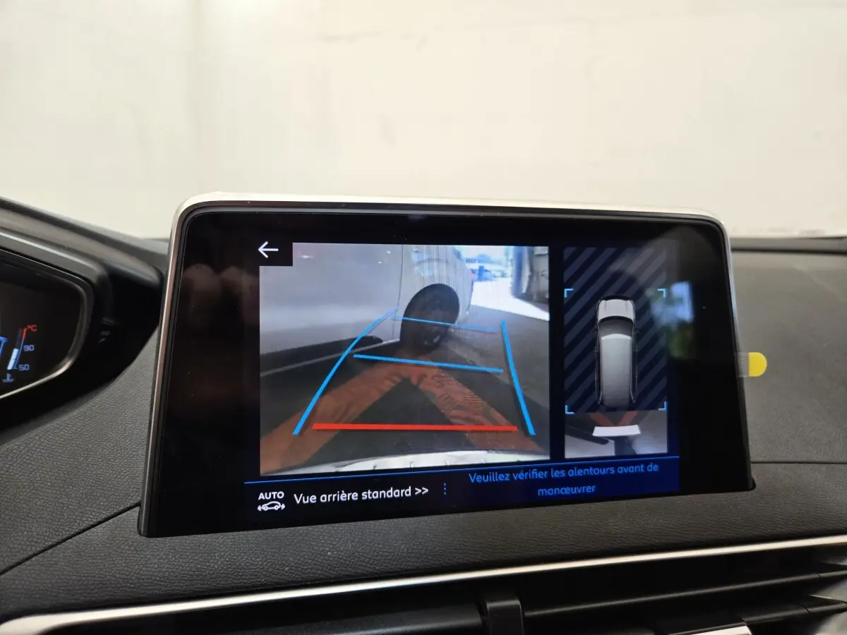 Écran tactile intérieur montrant la caméra de recul et l'aide au stationnement du Peugeot 5008 gris clair.