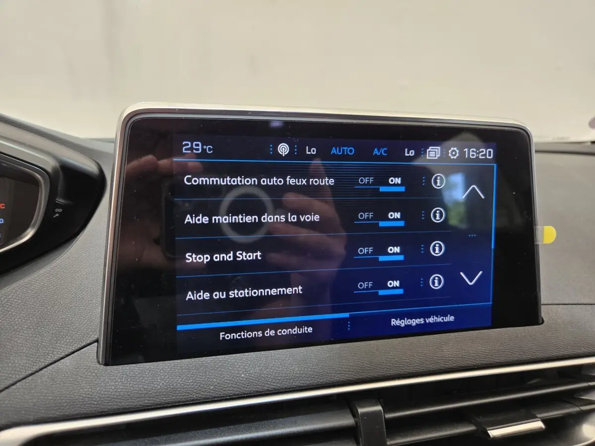 Écran tactile central affichant les réglages d’aide à la conduite dans l’habitacle d’un Peugeot 5008 gris.