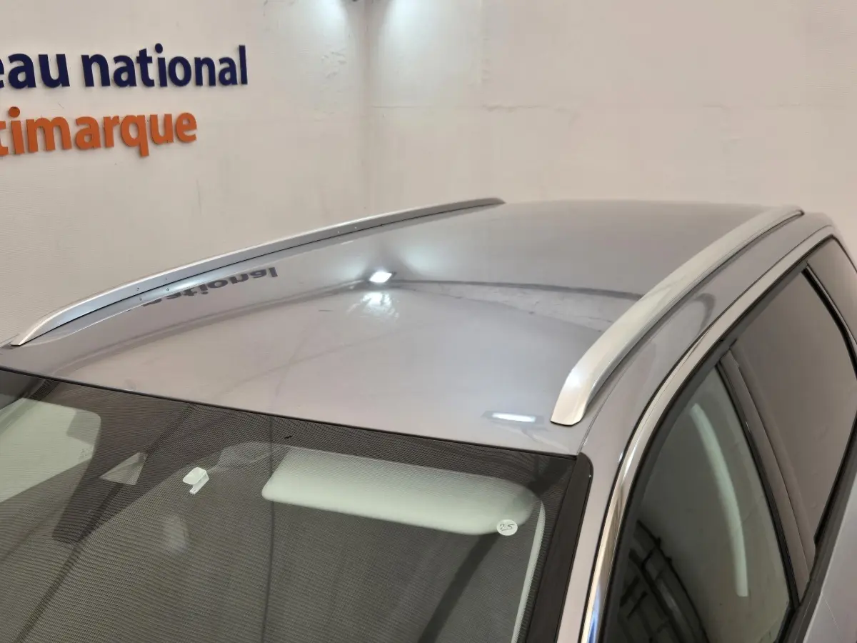 Vue plongeante sur le toit gris clair du Peugeot 5008 avec barres de toit chromées et vitres teintées côté droit.