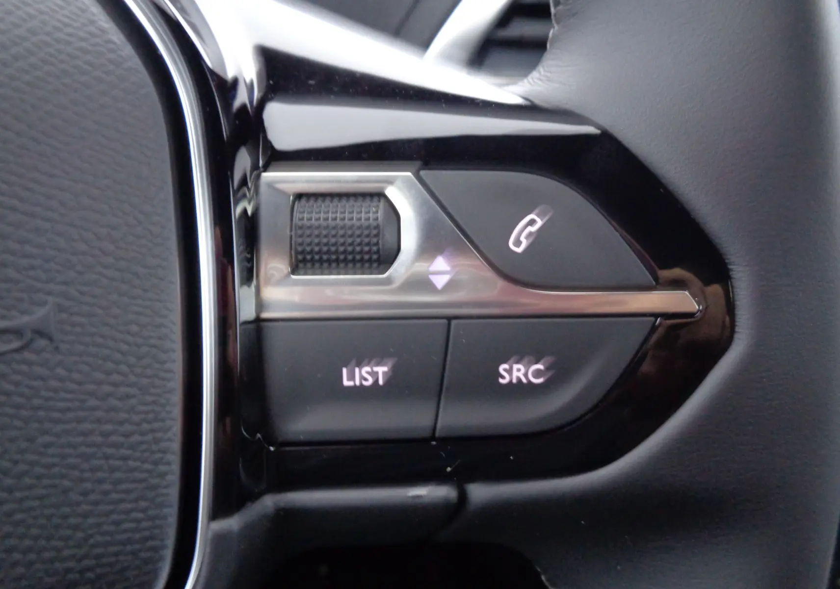 Gros plan sur les commandes gauche du volant du Peugeot 3008 noir Perla Nera 2023, boutons appel et liste.