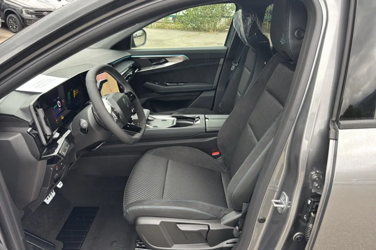 Vue intérieure côté conducteur du Renault Austral ETECH 200 Esprit Alpine Plus 2025, sièges noirs avec surpiqûres bleues.