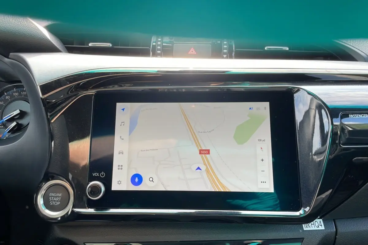 Vue rapprochée de l'écran tactile central et du bouton start/stop du Toyota Hilux 4x4 blanc pur 2025 Invincible.