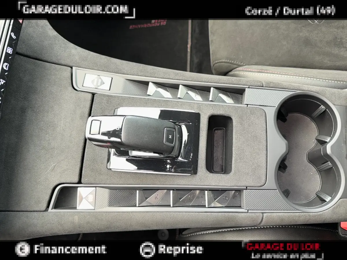 Vue plongeante sur la console centrale grise du DS7 Crossback blanc, mettant en valeur le levier de vitesse automatique et les boutons de commande.