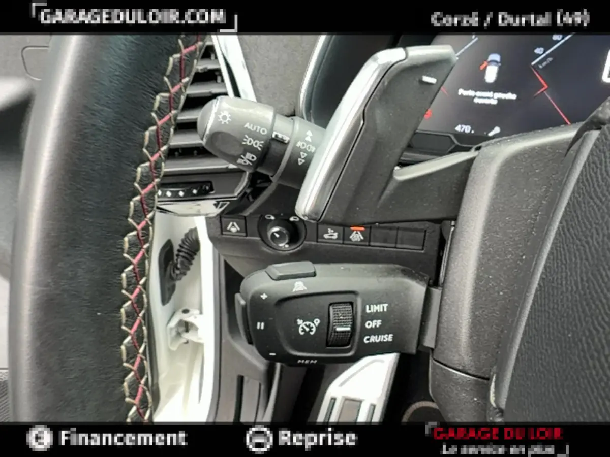 Gros plan sur la commande de régulateur de vitesse et volant cuir avec surpiqûres rouges dans DS7 Crossback blanc 2020.