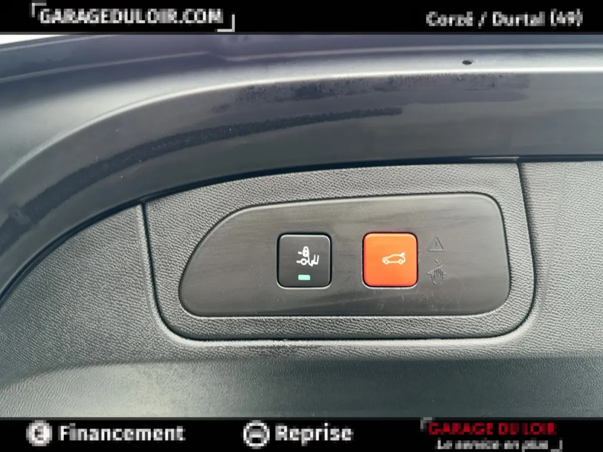 Gros plan sur les boutons de commande du hayon et du verrouillage dans un DS7 Crossback blanc, intérieur noir.