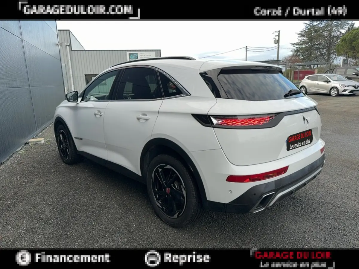 DS7 Crossback blanc vue 3/4 arrière droit, feux arrière LED et jantes noires distinctives visibles.