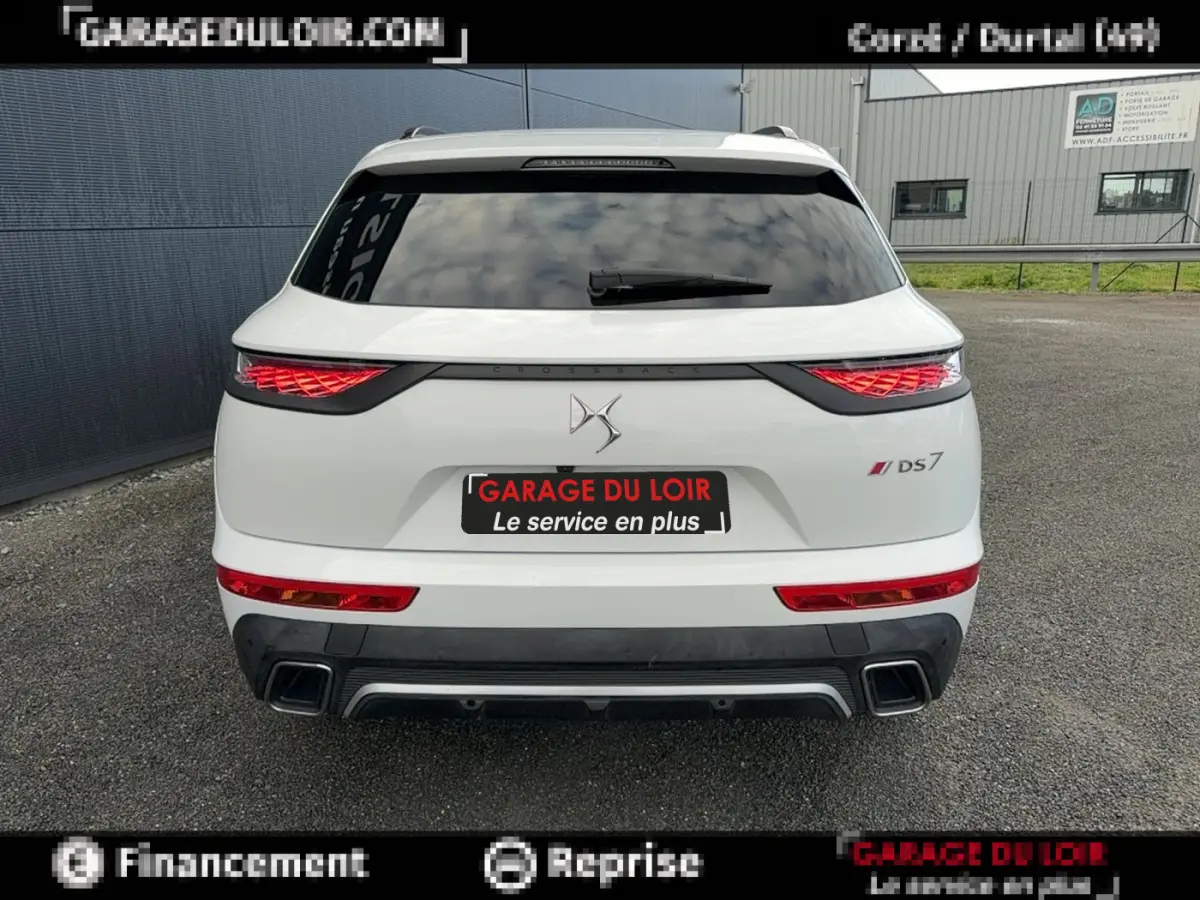 Vue arrière d’un DS7 Crossback blanc avec feux LED distinctifs et double sortie d’échappement carrée.