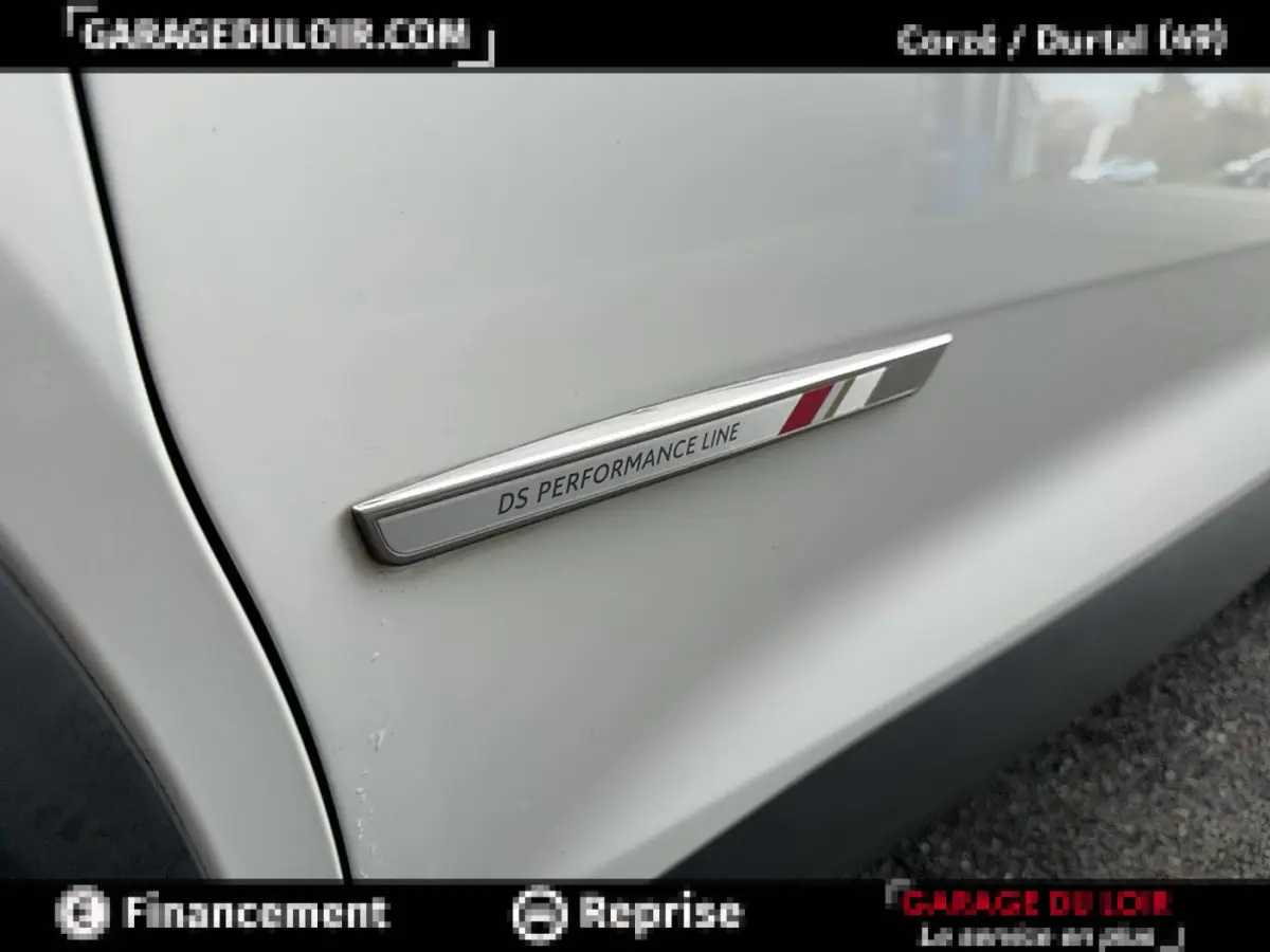 Gros plan sur l’inscription DS Performance Line sur la porte blanche côté gauche d’un DS7 Crossback.