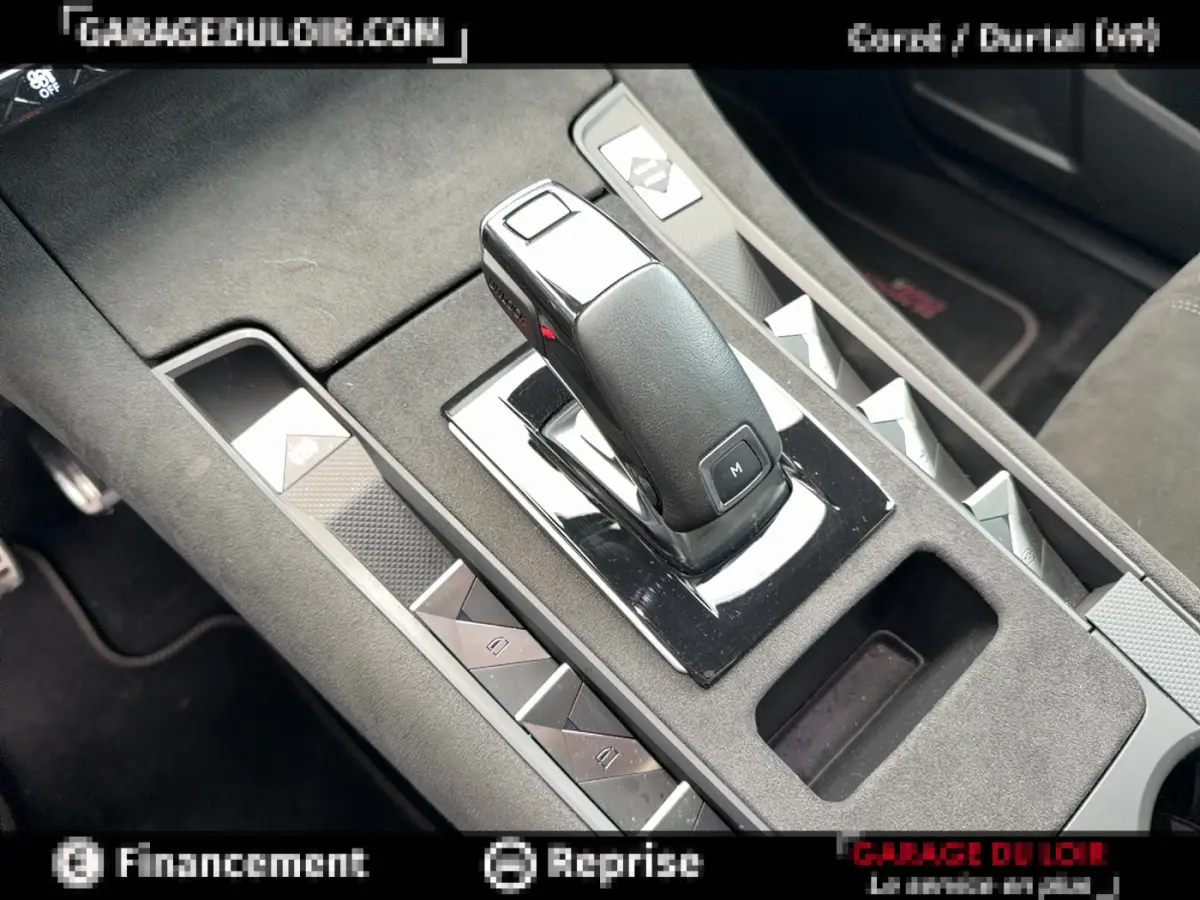 Gros plan sur la console centrale noire avec levier de vitesse automatique et commandes des vitres du DS7 Crossback blanc.