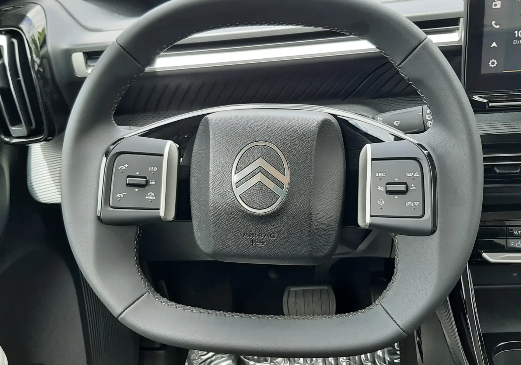 Vue rapprochée du volant carré noir de la Citroën C3 Aircross 2026, avec commandes intégrées et tableau de bord moderne.