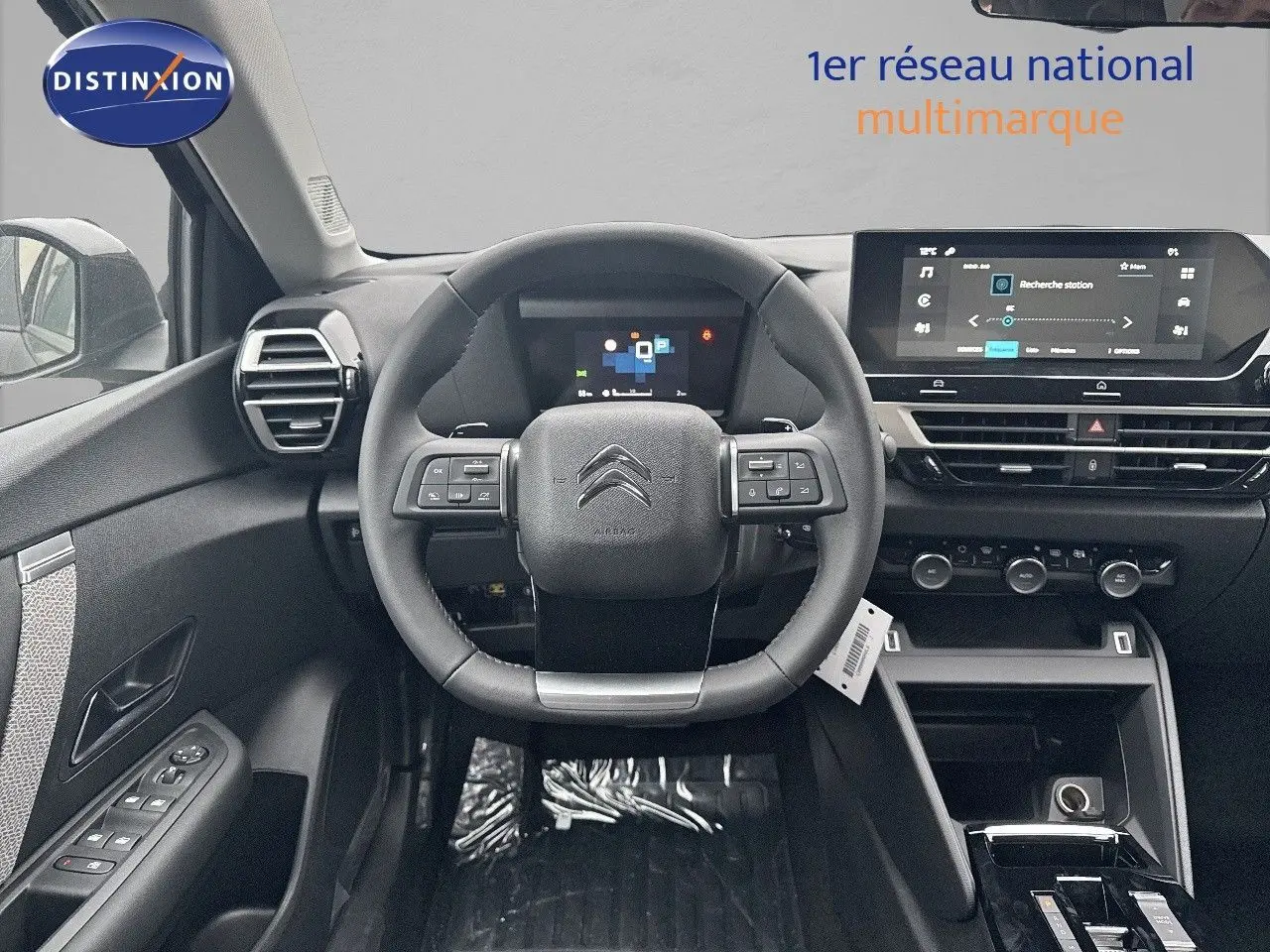 Intérieur noir de la Citroën C4 2024, vue frontale du poste de conduite avec volant multifonction et écran tactile.