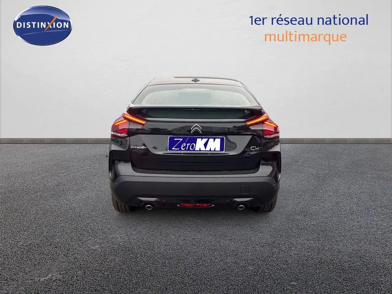 Vue arrière d'une Citroën C4 noire métal 2024 avec feux LED allumés et double sortie d'échappement visible.