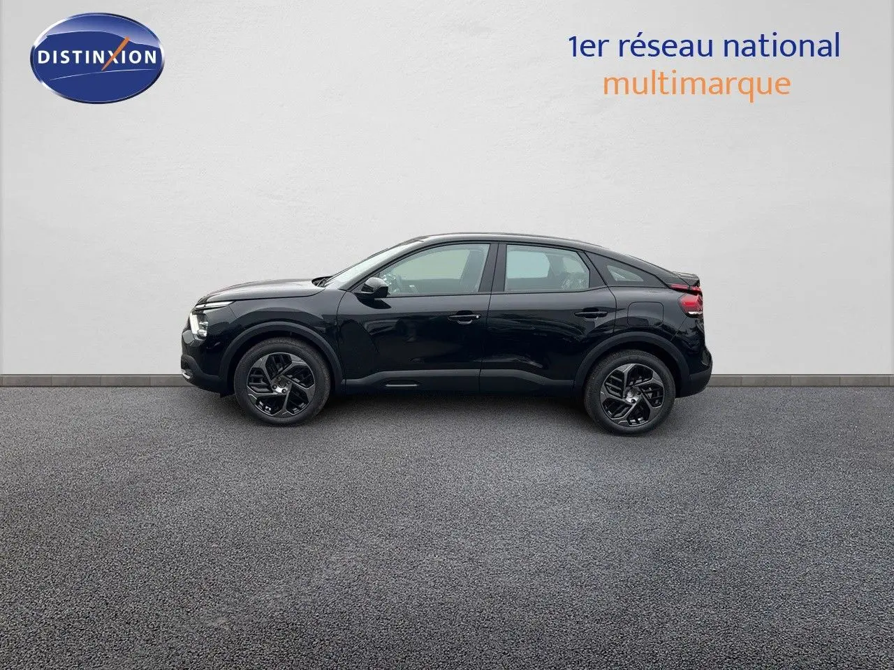 Profil côté gauche d'une Citroën C4 2024 noir métal avec jantes bi-ton et lignes fluides modernes.