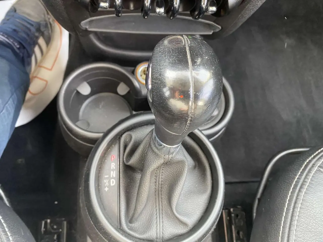 Le levier de vitesse automatique en cuir noir de la MINI Countryman 2015, avec porte-gobelets et siège en cuir visible.