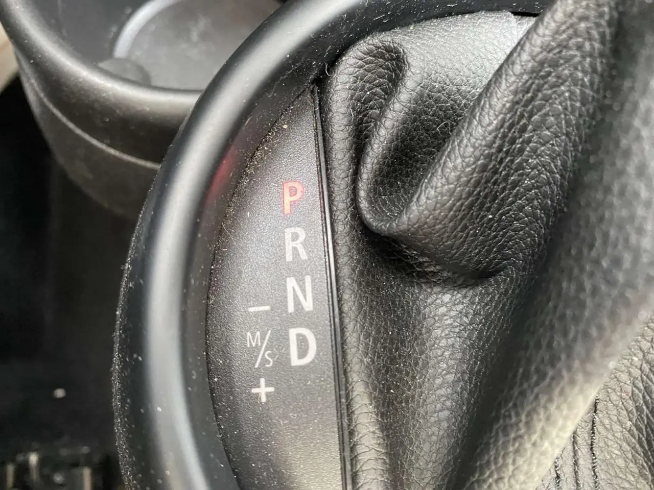 Le levier de vitesses automatique noir en cuir du MINI Countryman gris clair, avec indication P R N D visible.