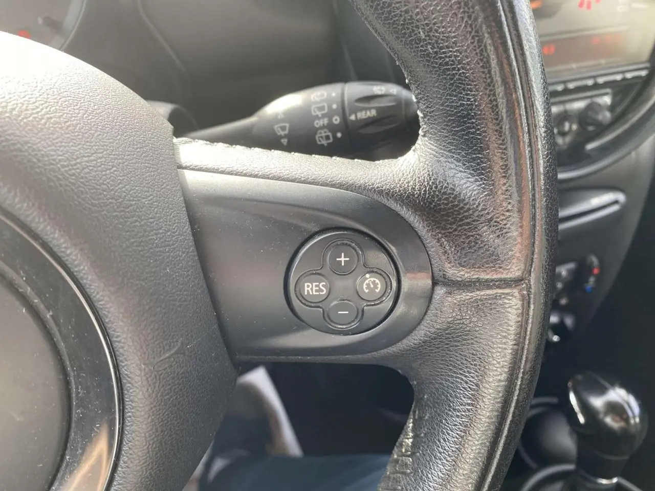 Gros plan sur le volant en cuir noir du MINI Countryman gris clair, avec commandes de régulateur de vitesse visibles.