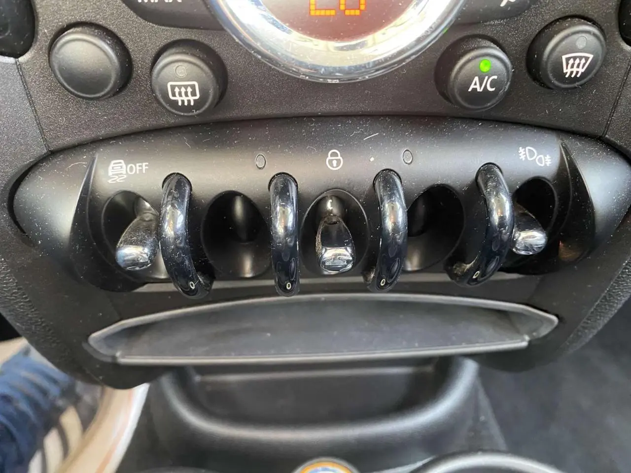 Gros plan sur les commandes à bascule noires du tableau de bord d'une MINI Countryman gris clair de 2015.