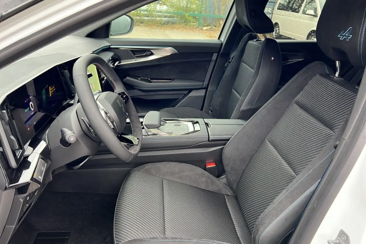 Intérieur côté conducteur du Renault Austral E-Tech 200 Esprit Alpine Plus 2025, sièges noirs avec surpiqûres bleues et logo Alpine.