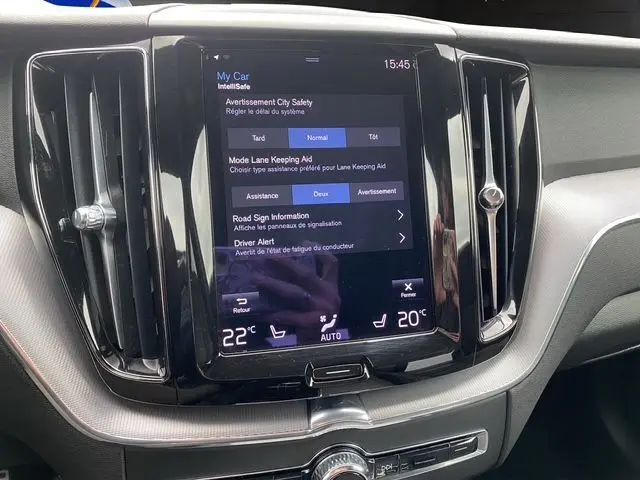 Écran tactile central du tableau de bord du Volvo XC60 noir 2021, affichant les réglages d'assistance à la conduite.