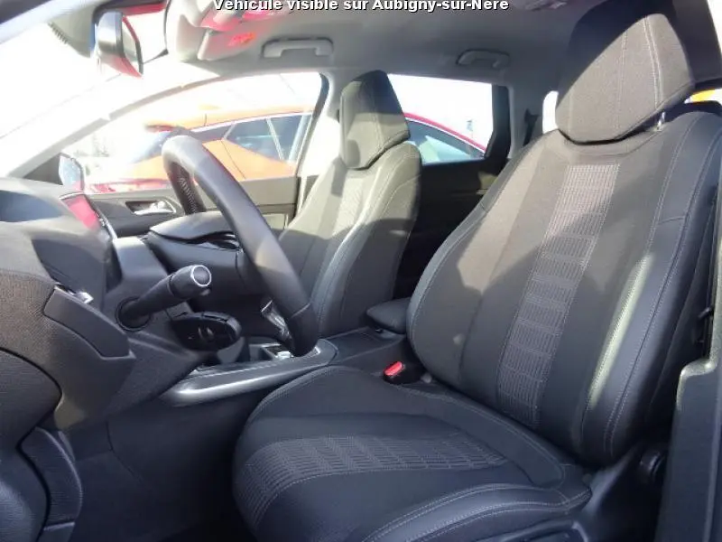 Vue intérieure côté conducteur du Peugeot 308 SW 2018 avec sièges tissu noir et volant compact du i-Cockpit.
