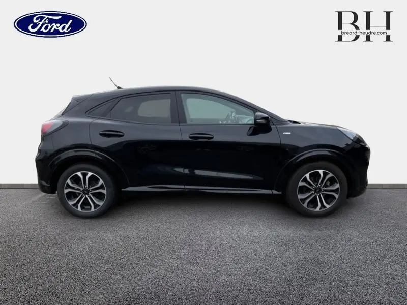 Vue latérale droite du Ford Puma noir Agate métallisé 2021 avec jantes alliage et vitres arrière surteintées.