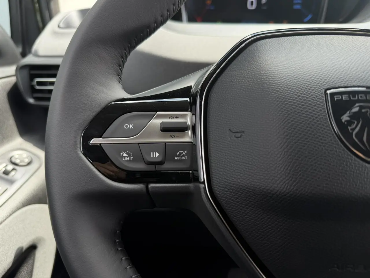 Gros plan sur le volant cuir multifonction du Peugeot Rifter 2026, avec commandes intégrées côté gauche.